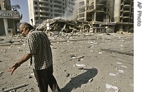Man reacts as he walks past destroyed building attacked by Israeli warplane missiles, in southern suburbs of Beirut, Monday