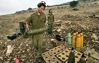 Israeli gunner prepares next shell after artillery piece fires towards Lebanon  