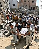 Lebanese civil defense rescuers carry body of a victim in Ghaziyeh, August 7, 2006 