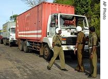 Sri Lankan soldiers inspect a container that was damaged during an artillery attack by Tamil Tiger rebels near the China Bay naval base in Trincomalee, in northeastern Sri Lanka, Saturday, August 12, 2006