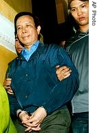 Vietnamese Deputy Transport Minister Nguyen Viet Tien is handcuffed and led from his home in Hanoi (File photo)