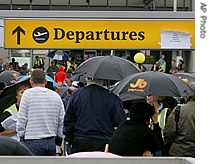 Passengers waiting to check in for their flights at Terminal 4 of London's Heathrow Airport, shelter under umbrellas as rain falls, Monday August 14, 2006
