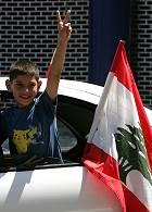 A displaced Lebanese boy flashes a victory sign