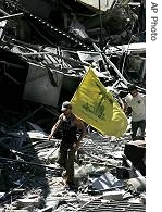 A Hezbollah supporter carries the group's flag as he walks through the rubble from Israeli bombardments in the southern suburbs of Beirut