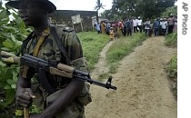 Local villagers look at a Nigeria soldier walking by in Archibong, a disputed area of southern Bakassi Peninsula