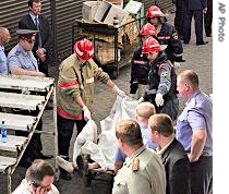 Rescuers carry the body of man killed by a blast, which hit a two-story trading arcade at a market in the northeastern part of Moscow, Monday, August 21, 2006 