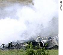 Firemen work at the crash site of the Russian Tupolev-154 plane, east of Kiev, August 22,2006