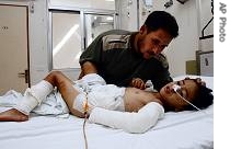 Lebanese Sobhi Abbas, top, comforts his son Abbas Abbas, 6-years-old, who was injured while playing with a cluster bomb in Blida, on Saturday August 26, 2006
