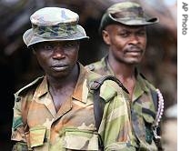 Two Nigerian army soldiers stand guard in Ikang, near Calabar in the Niger Delta area of Nigeria, Monday, August 14, 2006 
