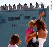 A woman holding her baby waves to soldiers aboard of the Italian Navy ship San Giorgio leaving for Lebanon 