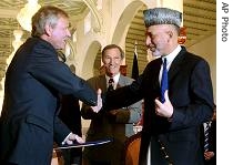 Afghan President Hamid Karzai, right, with NATO's secretary-general Jaap de Hoop Scheffer after exchanging signed documents of an accord to boost security and development cooperation in Kabul, September 6, 2006 