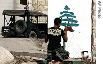 A Lebanese soldier paints cedar tree of Lebanese flag on a checkpoint on road in Kfar Kila, south Lebanon