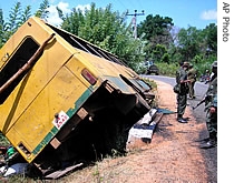 Soldiers patrol near a bus overturned by a landmine blast in Kabithigollewa, about 210 kilometers northeast of Colombo, Sri Lanka (file photo)