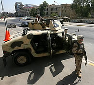Iraqi army soldiers stand guard with their armored vehicle on a deserted street during prayer day vehicle ban, in Baghdad, Iraq, Friday, Sept. 15, 2006