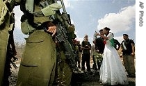 A Palestinian and his wife, an American of Palestinian origin, argue with Israeli soldiers shortly after their wedding ceremony, as part of a protest against Israeli barrier near Ramallah, July 2006