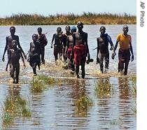 Residents of the Southern Nationalities, Nations and People's State in Ethiopia walk 18 August 2006 through flooded lands from which they have been forced to fleed after massive flashfloods in Tolta, Ethiopia 