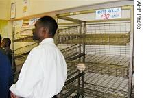 Zimbabwean man walks past empty bread shelves in central Harare, September 20, 2006