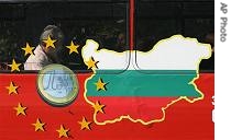 A man reads a newspaper behind a bus window painted with the EU sign and a map of Bulgaria, in Sofia, September 25, 2006