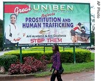 Student at Benin University walks past a billboard encouraging young women to fight against prostitution, in Benin City, Nigeria  