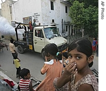 Children hold their noses to avoid fumes from municipality fumigant sprayer in New Delh, Oct. 3, 2006 