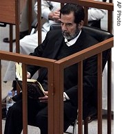 Saddam Hussein reads the Quran as he listens to witness testimony, Monday, Oct. 9, 2006