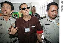 Ly Tong, center, a South Vietnamese air force veteran who later became a US citizen, talks to reporters at Criminal Court in Bangkok, September 7, 2006