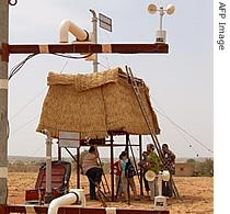 Scientists of the mission AMMA (African Monsoon Multidisciplinary Analysis) work near a dust sensor, July 9, 2006 near Niamey, Niger
