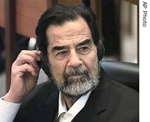 Saddam Hussein adjusts his headphones as he listens to witness testimony during his trial in Baghdad's heavily fortified Green Zone, October 17, 2006 