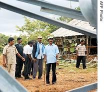 Head of Tamil Tiger political wing, S. P. Thamilselvan (2R) inspects damage to their radio transmitting station in Kokkavil, October 17, 2006
