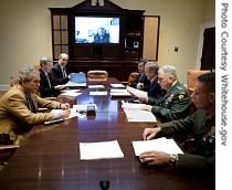 President George W. Bush (left) speaks during a video teleconference with Vice President Dick Cheney, on screen, and military commanders in the Roosevelt Room of the White House 