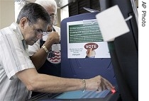 Jose DeLa Hoz, left, practices on a demo voting machine before casting his ballot as Eduardo Barros, Sr., looks on in Miami, Monday, Oct. 23, 2006