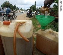 An unidentified Nigerian youth sells black market fuel after angry villagers took over Shell oil platforms