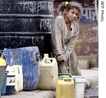 Indian girl collects drinking water from a tank at a slum in New Delhi