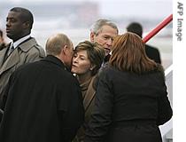 Russian President Vladimir Putin (c) kisses US First Lady Laura Bush as US President George W. Bush (back- 2nd-r) greets President Putin's wife Lyudmila Putin (r) upon arrival at Vnukovo Airport, Nov. 15, 2006