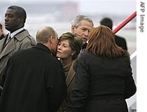 Russian President Vladimir Putin (c) kisses US First Lady Laura Bush as US President George W. Bush (back- 2nd-r) greets President Putin's wife Lyudmila Putin (r) upon arrival at Vnukovo Airport, Nov. 15, 2006 