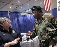 James Johnson, a 22-year Army veteran, talks with Pat Cooke, left, a recruiter for the Clearwater, Fla. police department, at a veterans job fair in New York