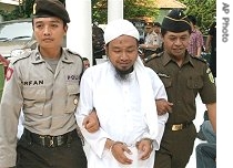 Subur Sugiarto, center, is escorted by police officers to a courtroom for his trial in Semarang, Central Java, Nov. 22, 2006<br />