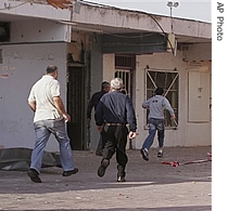 Residents of Sderot in southern Israel run for shelter as a siren is heard signaling an incoming rocket, 24 Nov. 2006