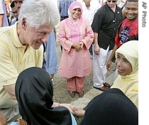 UN special envoy for tsunami recovery former US President Bill Clinton, left, shakes hands with refugees during his visit to a refugee barrack in Banda Aceh, Indonesia