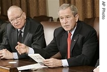 President Bush, right, holds a copy of the Iraq Study Group report as Group Co-Chairman Lee Hamilton looks on, 6 Dec. 2006