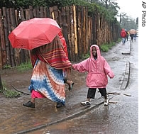 A Kenyan woman and her child walk in the rain in the Kibera slum in Nairobi, Kenya (File)