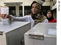 Acehnese woman casts her ballot at a polling station in Banda Aceh, 11 Dec 2006 