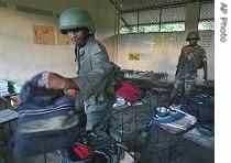 Sri Lankan soldiers sort the belongings of students at a school which came under artillery attack by Tamil Tigers in North Eastern village Kallaru, 7 Dec. 2006<br /><br />