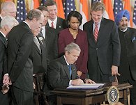 President Bush, seated, center, surrounded by members of Congress and officials, signs US-India Peaceful Atomic Energy Cooperation Act at the White House, 18 Dec 2006