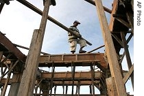 An Acehnese man works on building a new house in a village destroyed by the 2004 tsunami, in Banda Aceh, Dec. 10, 2006
