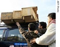 Iraqi tries to reach the coffin of his relative as it is being carried away from the morgue of a hospital in Baghdad, 21 Dec 2006