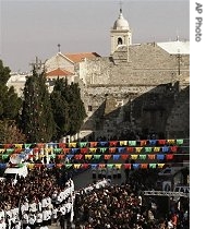 Palestinians and tourists gather for the traditional Christmas procession in Manger Square in front of the Church of the Nativity in Bethlehem