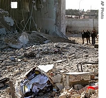 Iraqis look at the destroyed Jameat police station after it was demolished in a British army raid in Basra,Iraq, 25 Dec 2006
