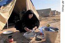 An Iraqi Shiite woman washes dishes in camp for Baghdad's displaced Shiite families in Diwaniyah, 130 kilometers south of Baghdad, 3 Jan 2007