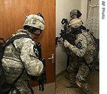 U.S. Army soldiers from the 5th Battalion, 20th Infantry Regiment throw open a door in an empty house during a predawn sweep of a neighborhood in southern Baghdad, 02 Jan 2007